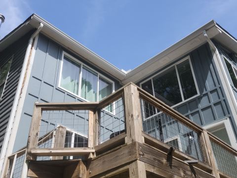 Deck with wire-panel railing beside board-and-batten siding
