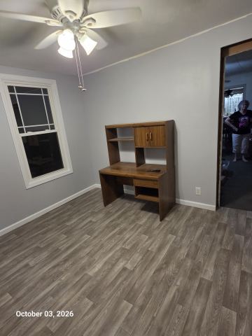 Painted room with ceiling fan, new flooring and white trim